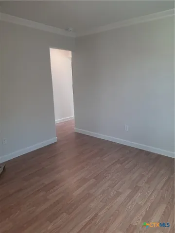 an empty room with wooden floor and a window