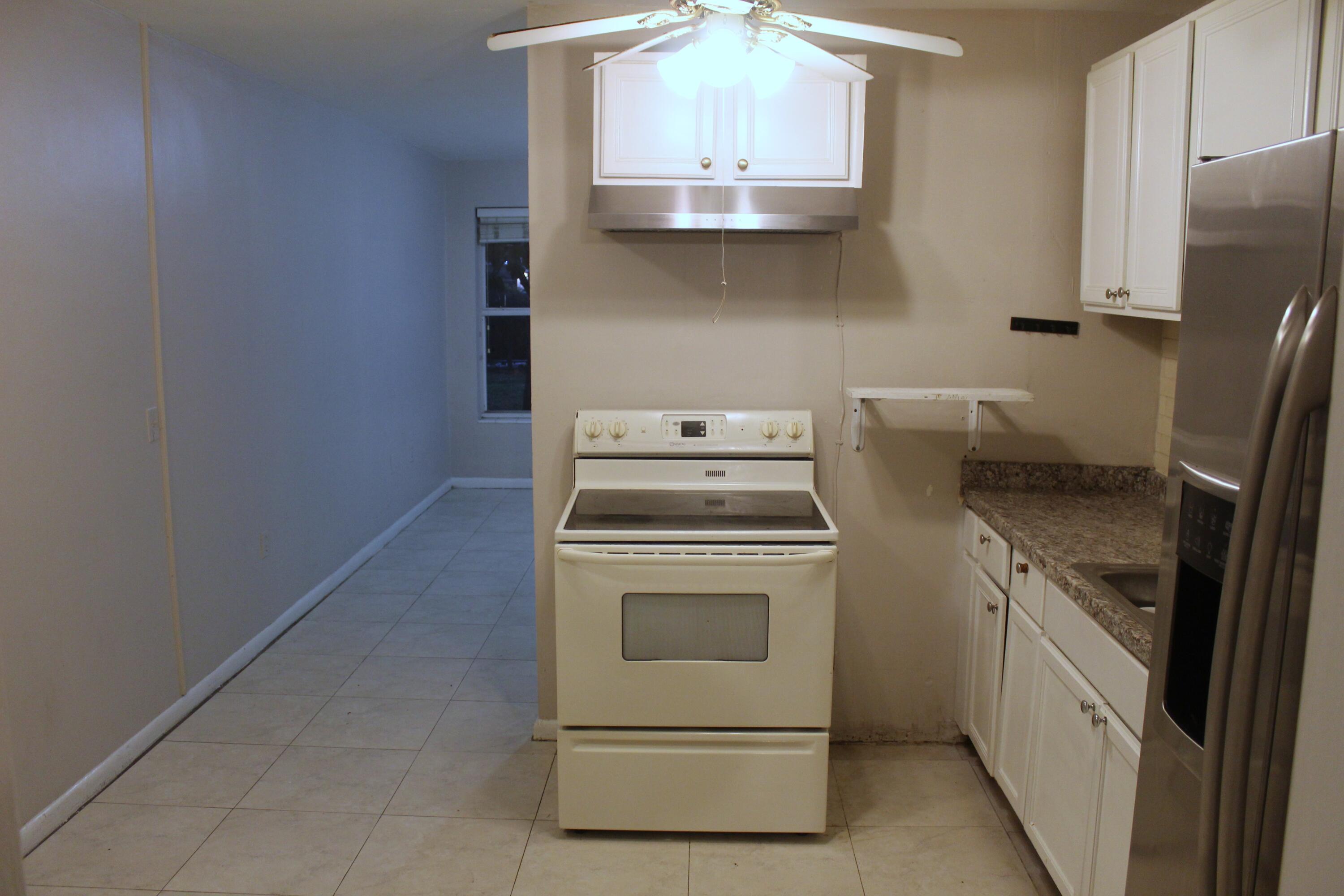 4434 Venus Avenue, Unit A West Palm Beach, FL 33406 - Photo 5 of 9 a kitchen with stainless steel appliances a white stove top oven and sink