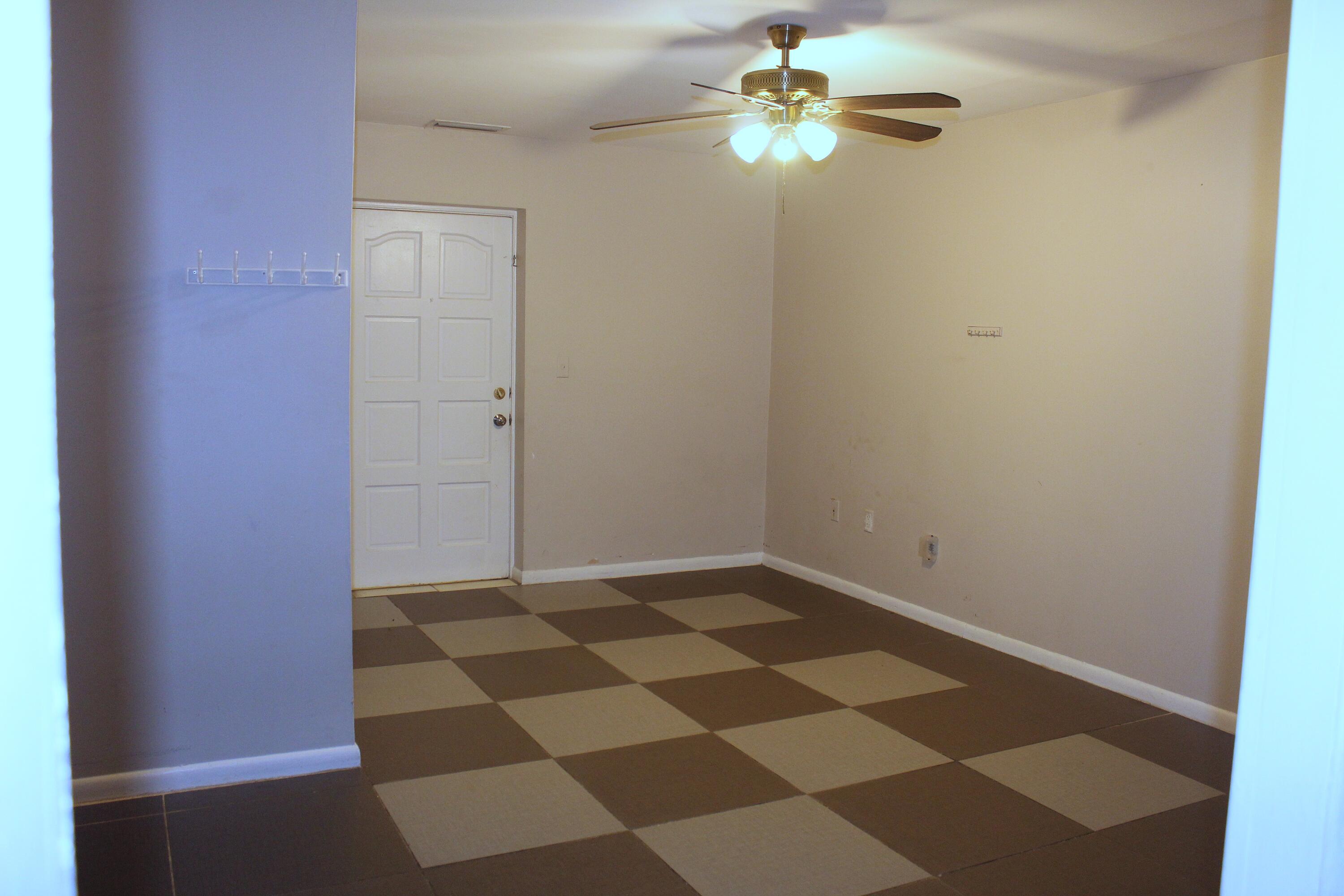4434 Venus Avenue, Unit A West Palm Beach, FL 33406 - Photo 6 of 9 an empty room with a piano and wooden floor