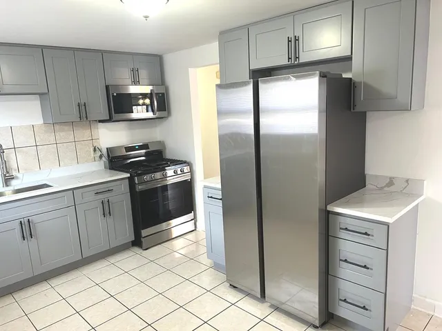 a kitchen with a refrigerator sink and cabinets