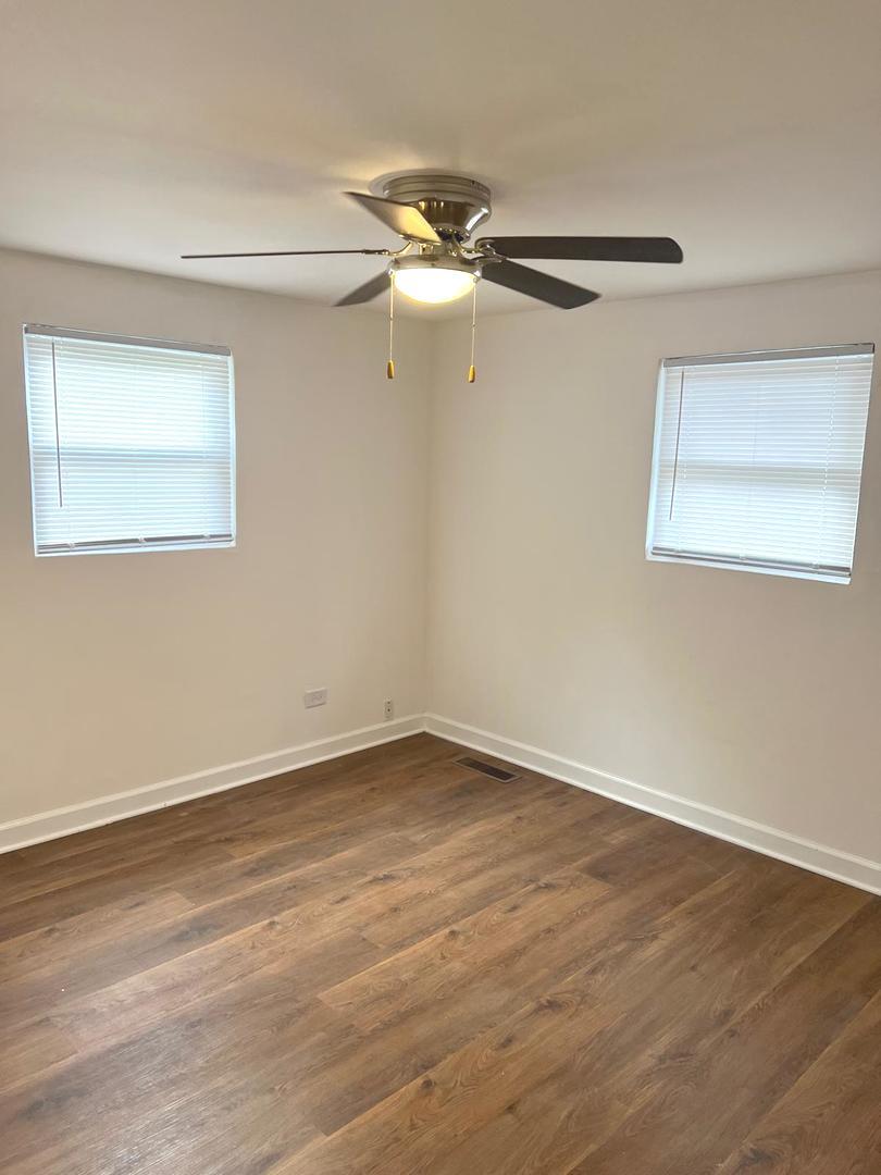 3101 Emery Lane Robbins, IL 60472 - Photo 15 of 22 a view of an empty room with wooden floor and a ceiling fan