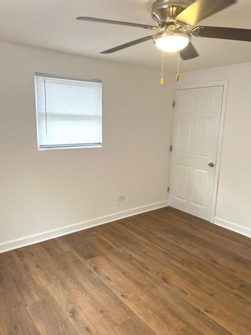 3101 Emery Lane Robbins, IL 60472 - Photo 17 of 22 a view of an empty room with wooden floor and a chandelier fan