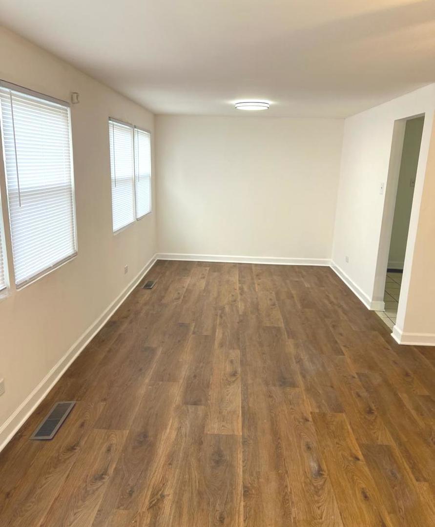 3101 Emery Lane Robbins, IL 60472 - Photo 7 of 22 an empty room with wooden floor and windows