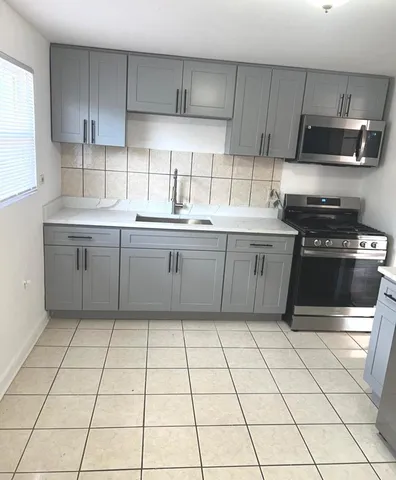 a kitchen with stainless steel appliances granite countertop a sink a stove a microwave and cabinets