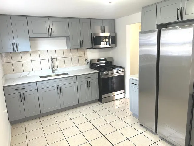 a kitchen with a refrigerator sink and cabinets