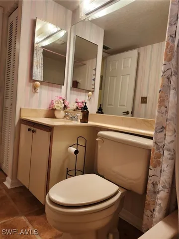 a bathroom with a toilet sink and mirror