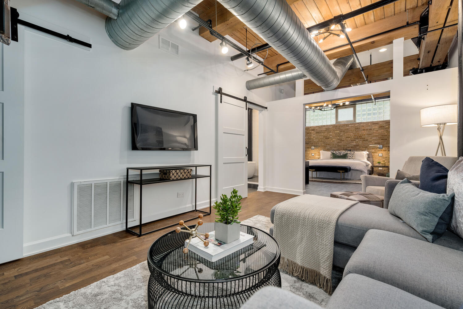 1000 West Washington Boulevard, Unit 148 Chicago, IL 60607 - Photo 20 of 29 a living room with furniture a flat screen tv and a floor to ceiling window