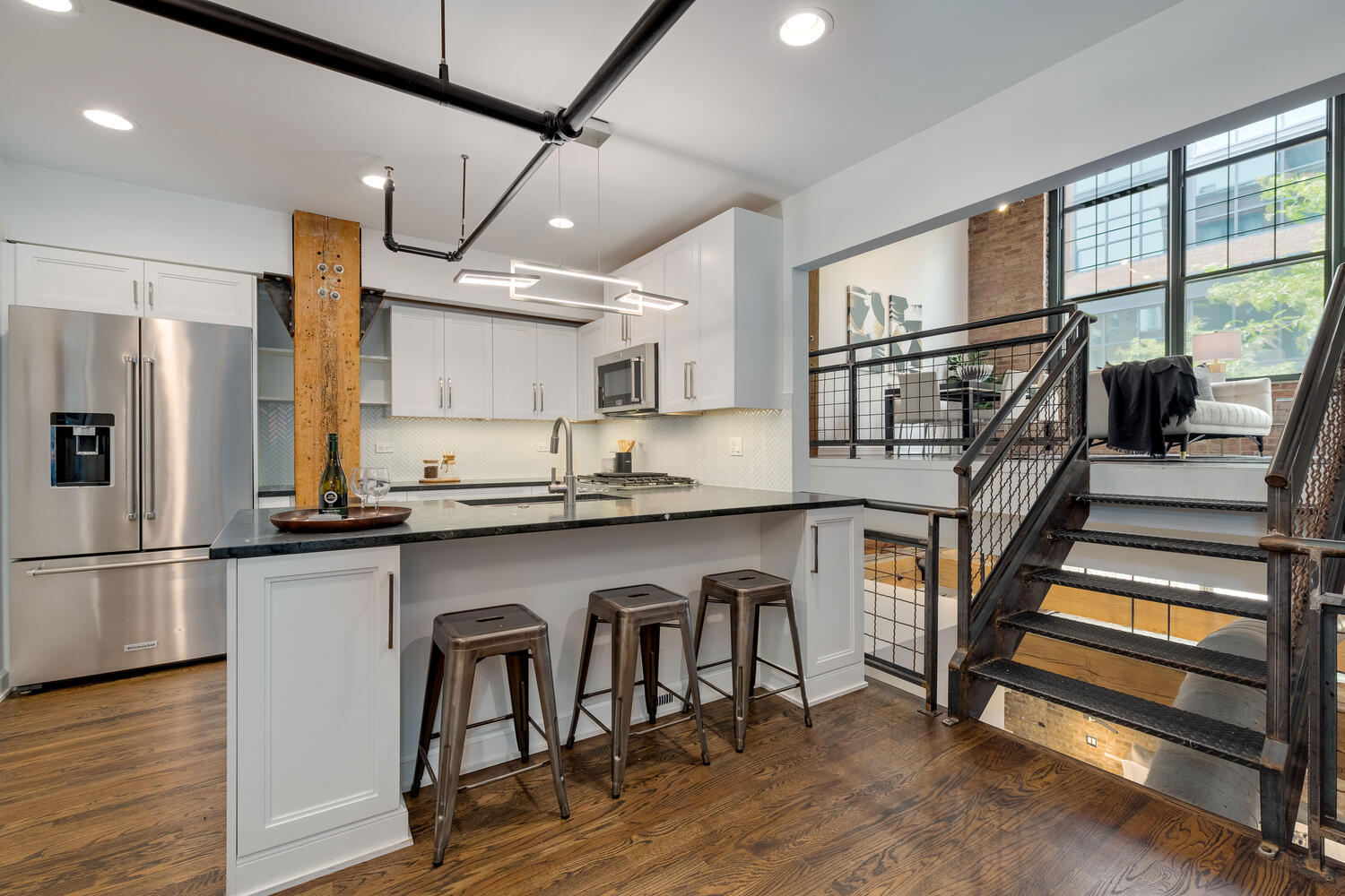1000 West Washington Boulevard, Unit 148 Chicago, IL 60607 - Photo 4 of 29 a kitchen with stainless steel appliances granite countertop a refrigerator a stove a sink and a dining table with wooden floor