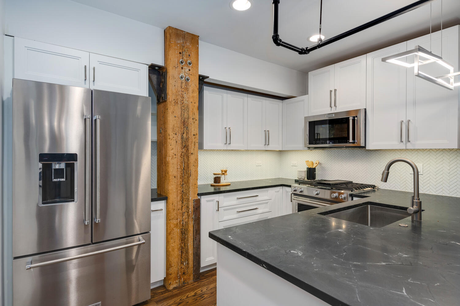 1000 West Washington Boulevard, Unit 148 Chicago, IL 60607 - Photo 5 of 29 a kitchen with stainless steel appliances granite countertop a refrigerator a stove a sink a kitchen island with a refrigerator and cabinets