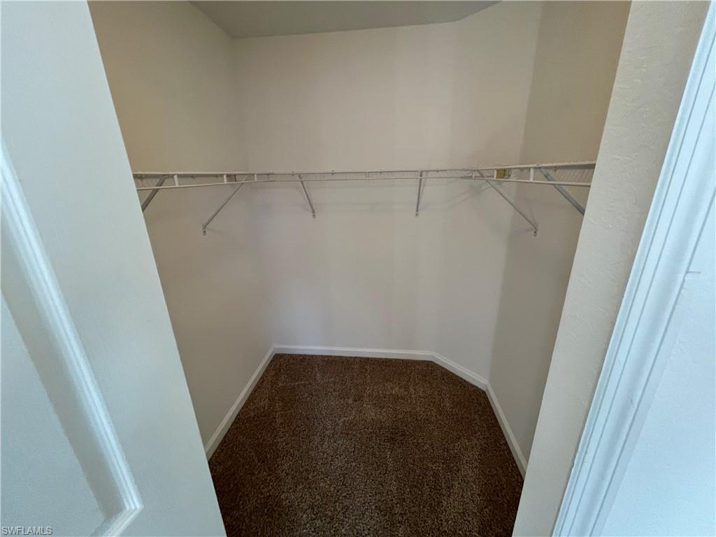 12940 Positano Circle, Unit 202 Naples, FL 34105 - Photo 11 of 33 a view of walk in closet with empty racks