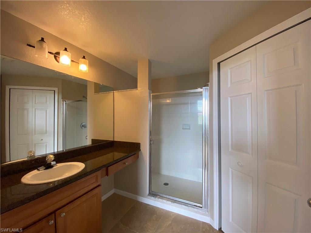 12940 Positano Circle, Unit 202 Naples, FL 34105 - Photo 12 of 33 a bathroom with a sink and a mirror