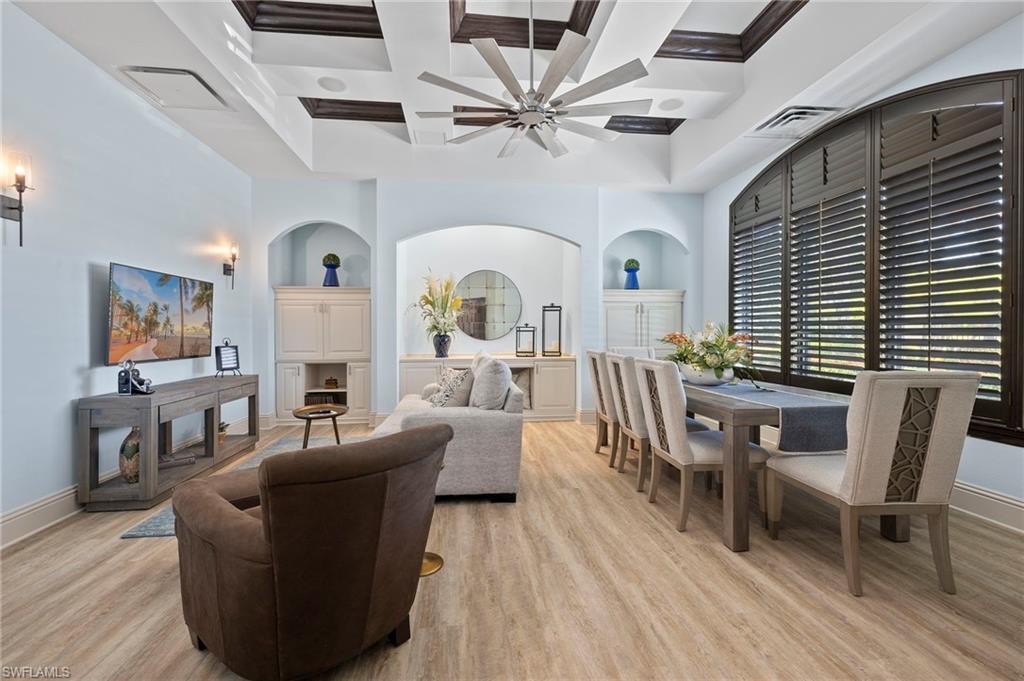 12940 Positano Circle, Unit 202 Naples, FL 34105 - Photo 31 of 33 a living room with furniture a fireplace and wooden floor