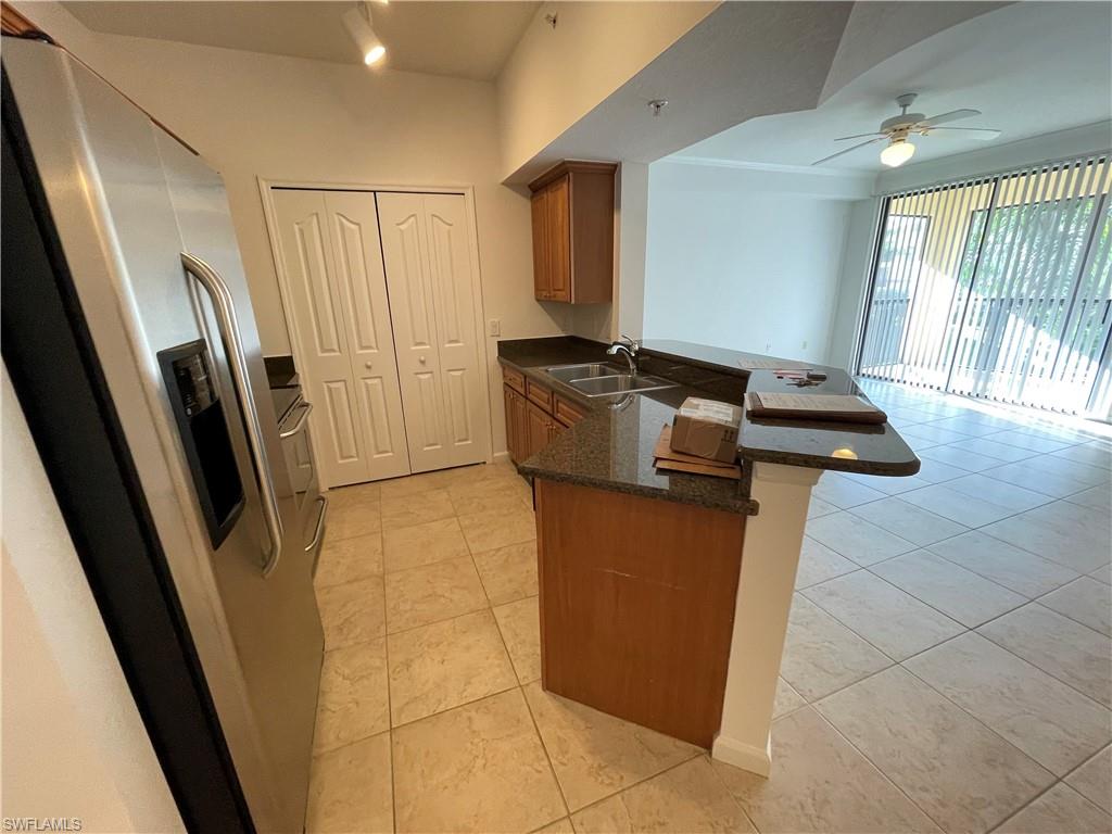 12940 Positano Circle, Unit 202 Naples, FL 34105 - Photo 6 of 33 a kitchen with stainless steel appliances granite countertop a refrigerator and a sink