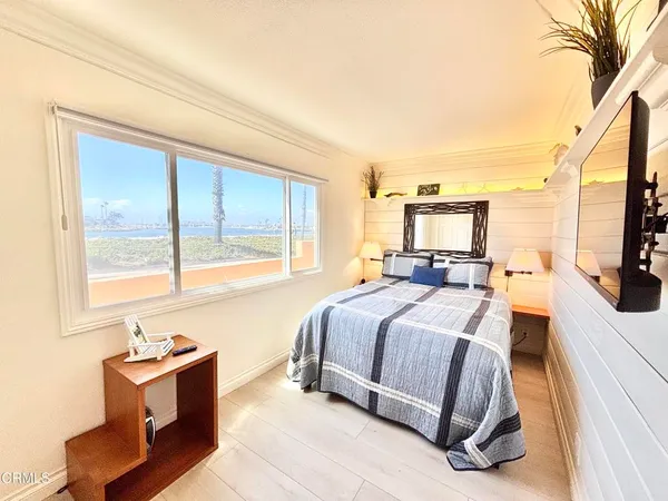 a spacious bedroom with a bed and large windows