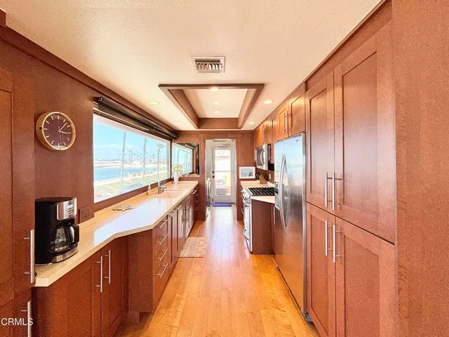 a view of a hallway with wooden floor and furniture