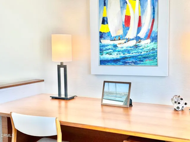 a view of a room with a sink and lots of painting on the wall