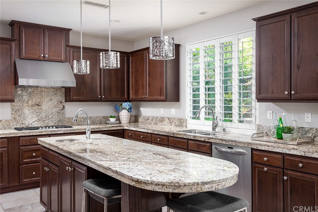 3932 Killymoon Circle Yorba Linda, CA 92886 - Photo 6 of 25 a kitchen with granite countertop kitchen island stainless steel appliances a sink stove and cabinets