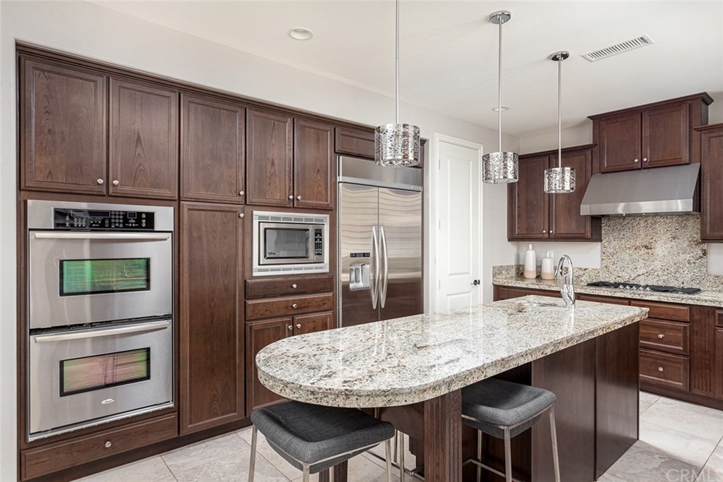 3932 Killymoon Circle Yorba Linda, CA 92886 - Photo 7 of 25 a kitchen with stainless steel appliances granite countertop wooden cabinets a stove a oven a sink and a oven