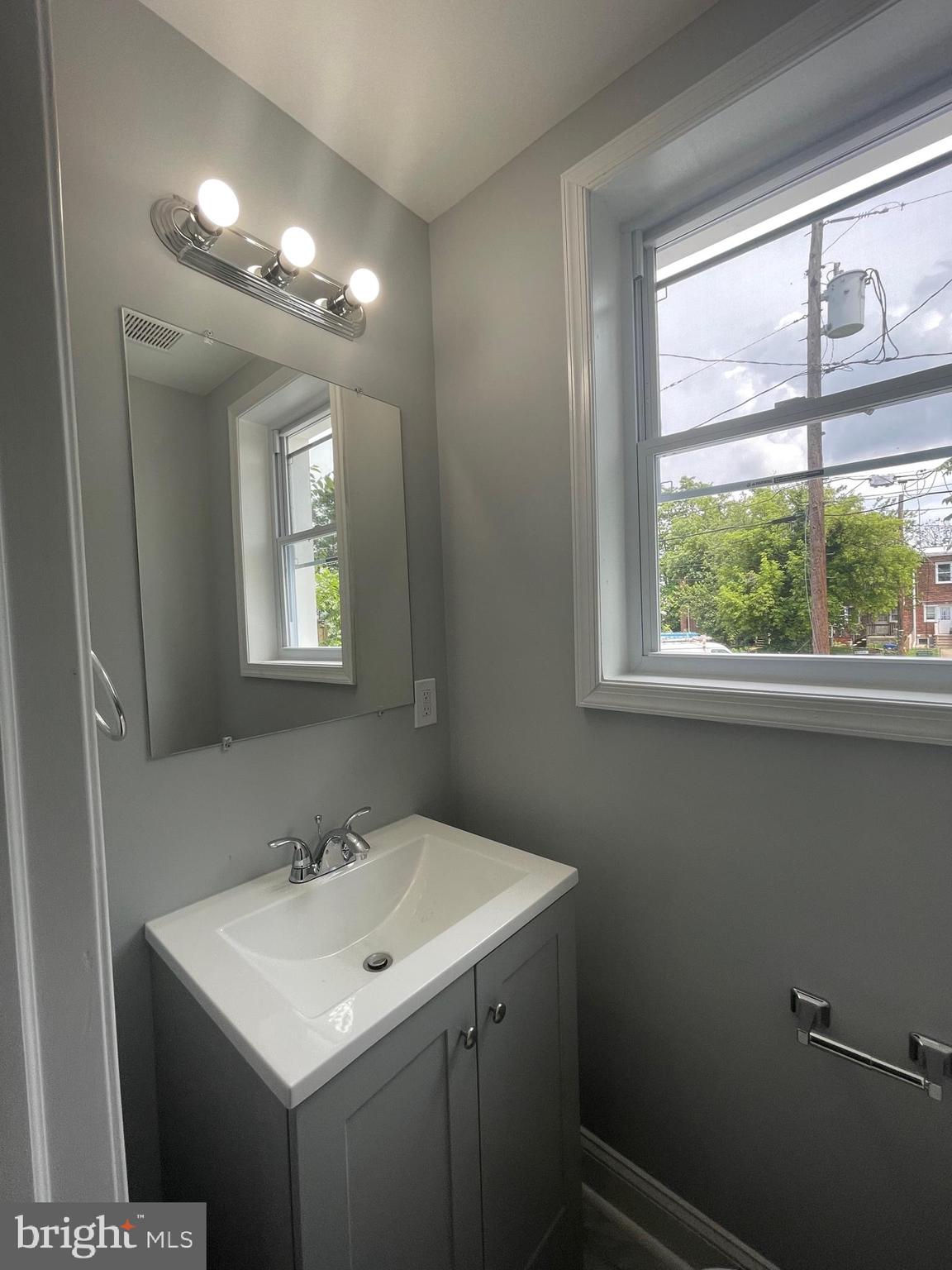 3619 Manchester Avenue Baltimore, MD 21215 - Photo 13 of 33 a bathroom with a sink a mirror and a window