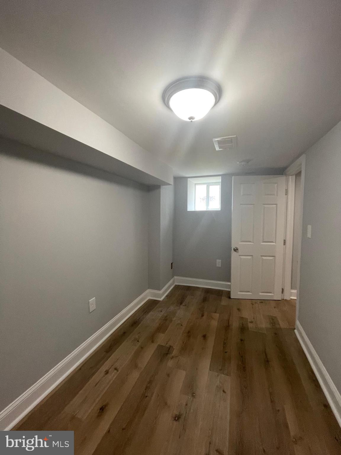 3619 Manchester Avenue Baltimore, MD 21215 - Photo 19 of 33 an empty room with wooden floor and windows