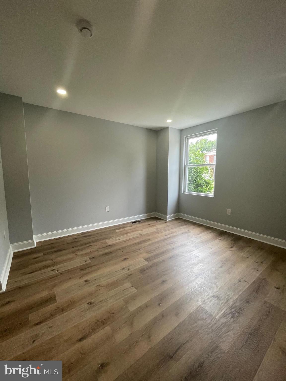 3619 Manchester Avenue Baltimore, MD 21215 - Photo 7 of 33 an empty room with wooden floor and windows