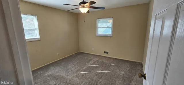 an empty room with chandelier fan