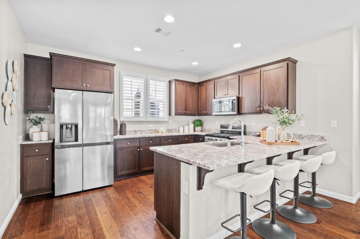 3406 Pyramid Way Mountain View, CA 94043 - Photo 7 of 41 a kitchen with stainless steel appliances granite countertop a refrigerator a sink dishwasher a stove and white countertops with wooden floor