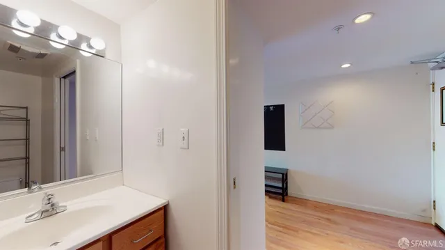 a bathroom with a sink a light fixture and a mirror