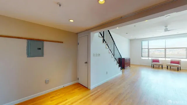 a view of an empty room with window and wooden floor