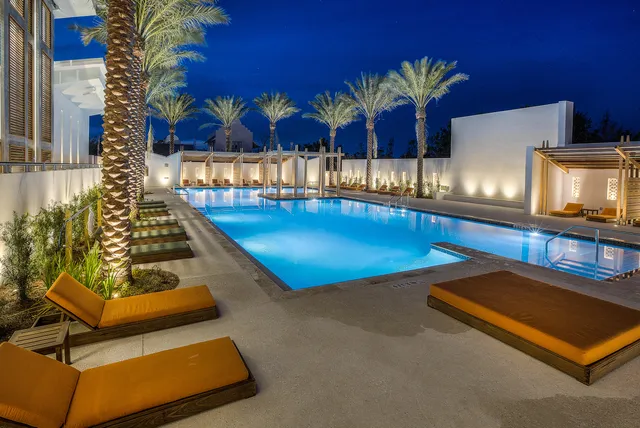 a living room with furniture pool table and wall paintings