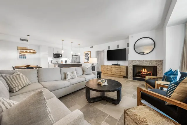 a living room with furniture a flat screen tv and a fireplace