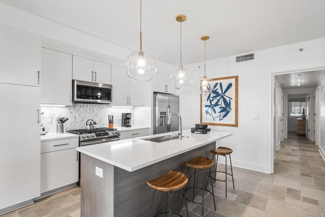 136 Georgetown Avenue, Unit 1A4 Inlet Beach, FL 32461 - Photo 5 of 27 a kitchen that has a kitchen island a stove a table and chairs in it
