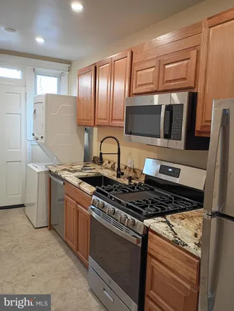 a kitchen with granite countertop a sink stainless steel appliances and cabinets
