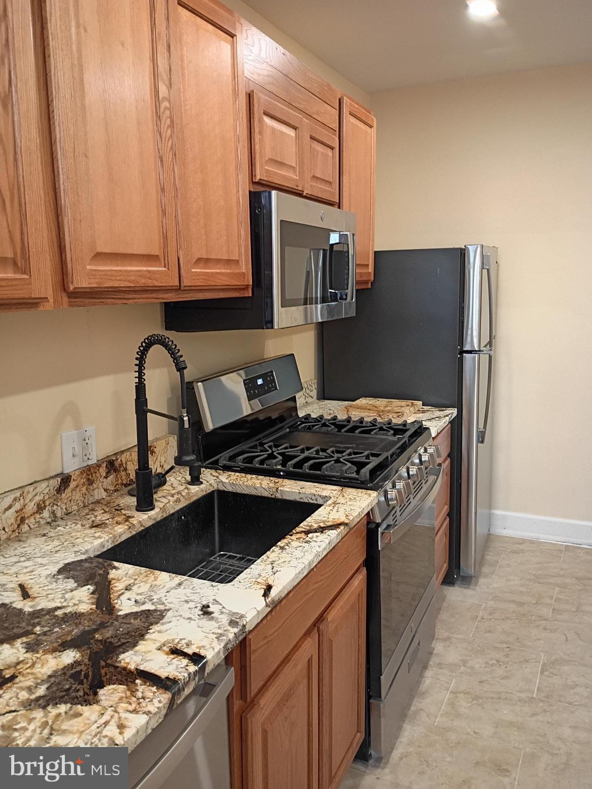 5220 4th Street Northwest, Unit 3 Washington, DC 20011 - Photo 3 of 10 a kitchen with granite countertop a sink stainless steel appliances and cabinets