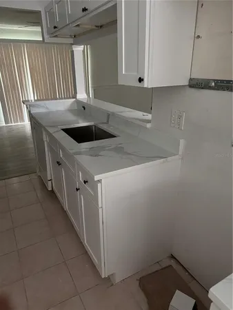 a kitchen with a sink a stove and cabinets