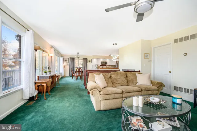 a living room with furniture floor to ceiling window and a flat screen tv