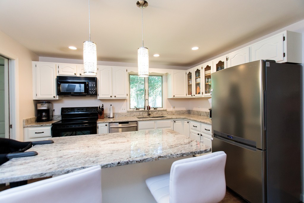 13 Pinewood Road Wellesley, MA 02482 - Photo 6 of 16 a kitchen with stainless steel appliances granite countertop a refrigerator a stove a sink a microwave and island