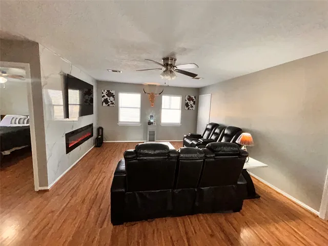 a living room with furniture and a wooden floor