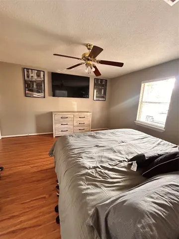 a bedroom with a large bed and a ceiling fan