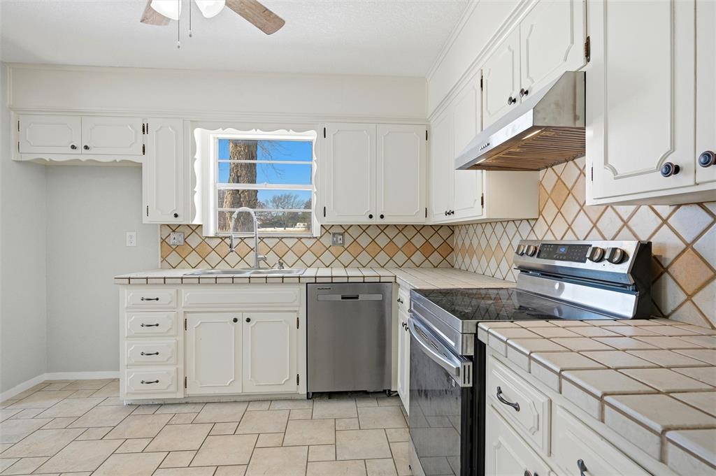 2611 Easy Street Denison, TX 75020 - Photo 13 of 32 a kitchen with granite countertop white cabinets and white appliances