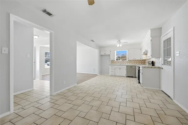a large white kitchen with cabinets and a refrigerator