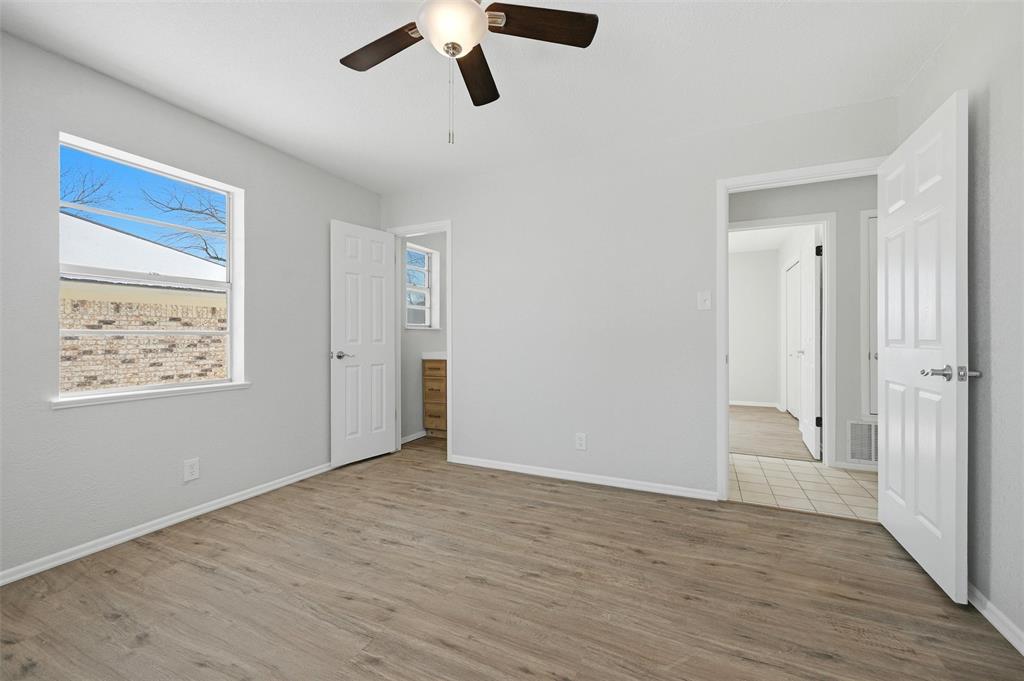 2611 Easy Street Denison, TX 75020 - Photo 17 of 32 an empty room with wooden floor cabinet and windows