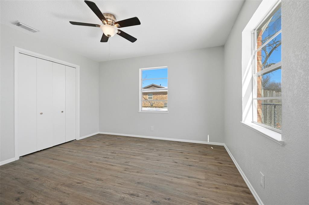 2611 Easy Street Denison, TX 75020 - Photo 19 of 32 an empty room with wooden floor ceiling fan and windows
