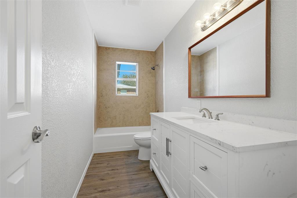 2611 Easy Street Denison, TX 75020 - Photo 23 of 32 a bathroom with a toilet a sink and mirror