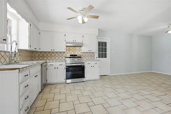 a kitchen with a stove a sink and a refrigerator