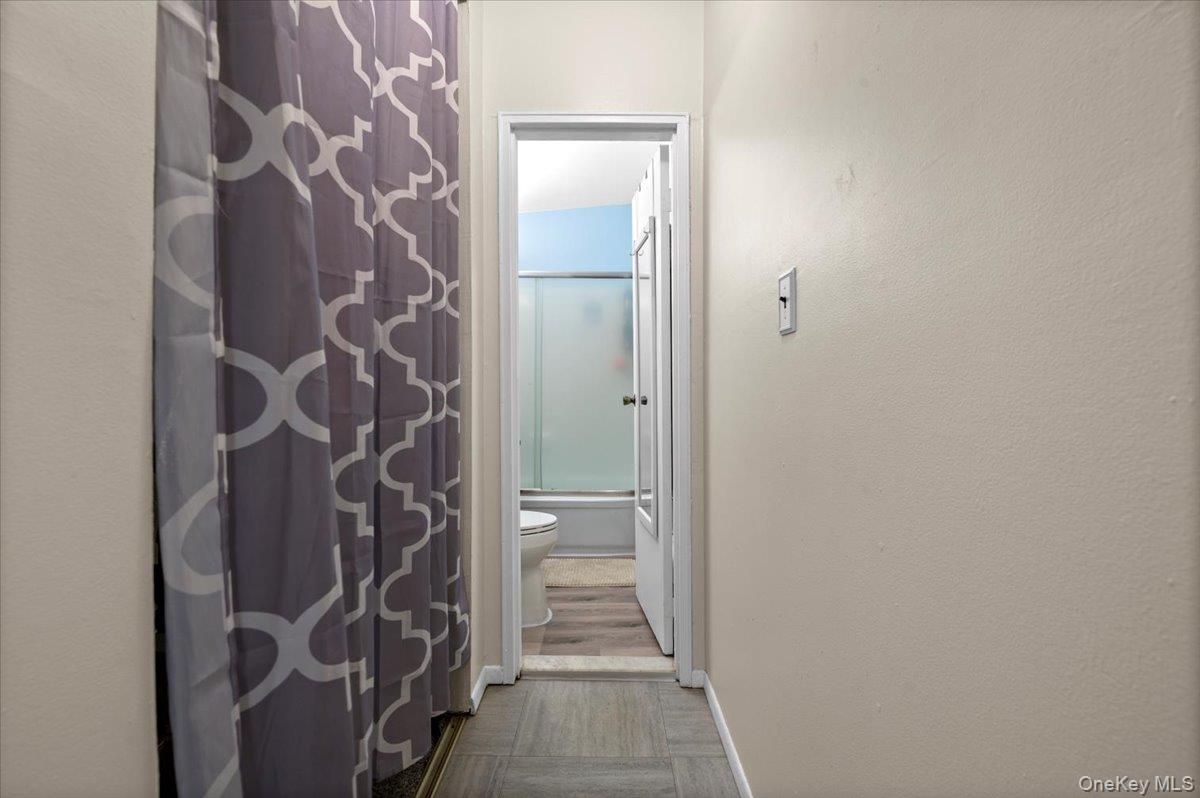267 North Newbridge Road, Unit 2D Levittown, NY 11756 - Photo 12 of 22 Hallway featuring light-toned walls and wood-finish flooring