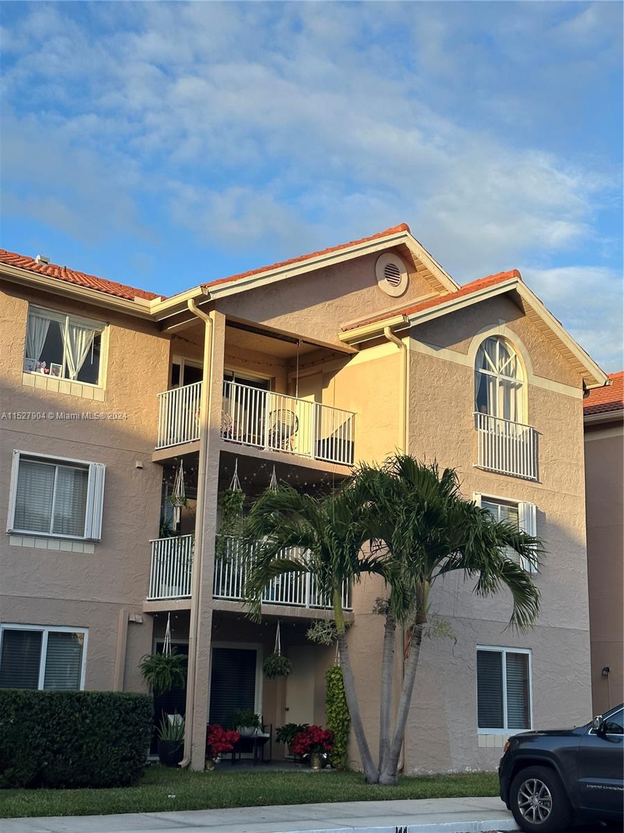 15821 Southwest 104th Terrace, Unit 203 Miami, FL 33196 - Photo 1 of 25 a front view of a house with a yard