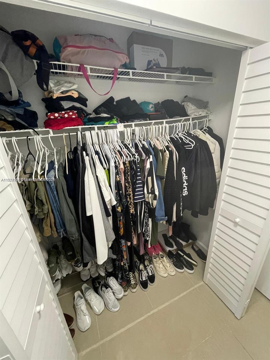 15821 Southwest 104th Terrace, Unit 203 Miami, FL 33196 - Photo 13 of 25 a view of walk in closet with clothes and shoes