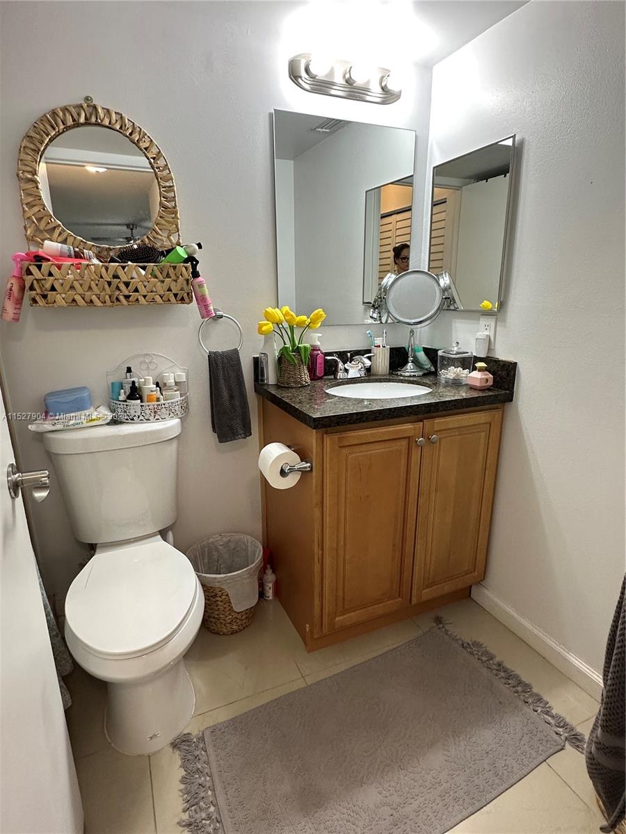 15821 Southwest 104th Terrace, Unit 203 Miami, FL 33196 - Photo 17 of 25 a bathroom with a toilet sink and mirror