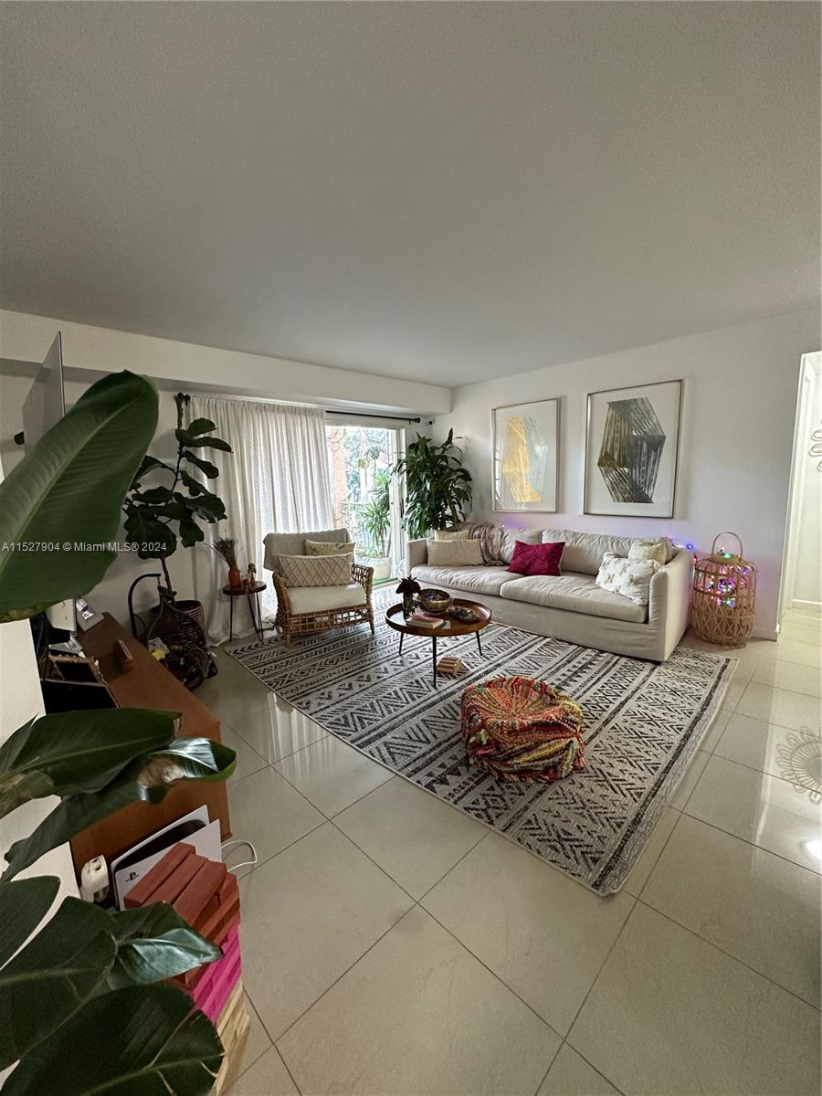 15821 Southwest 104th Terrace, Unit 203 Miami, FL 33196 - Photo 2 of 25 a bedroom with furniture and a chair